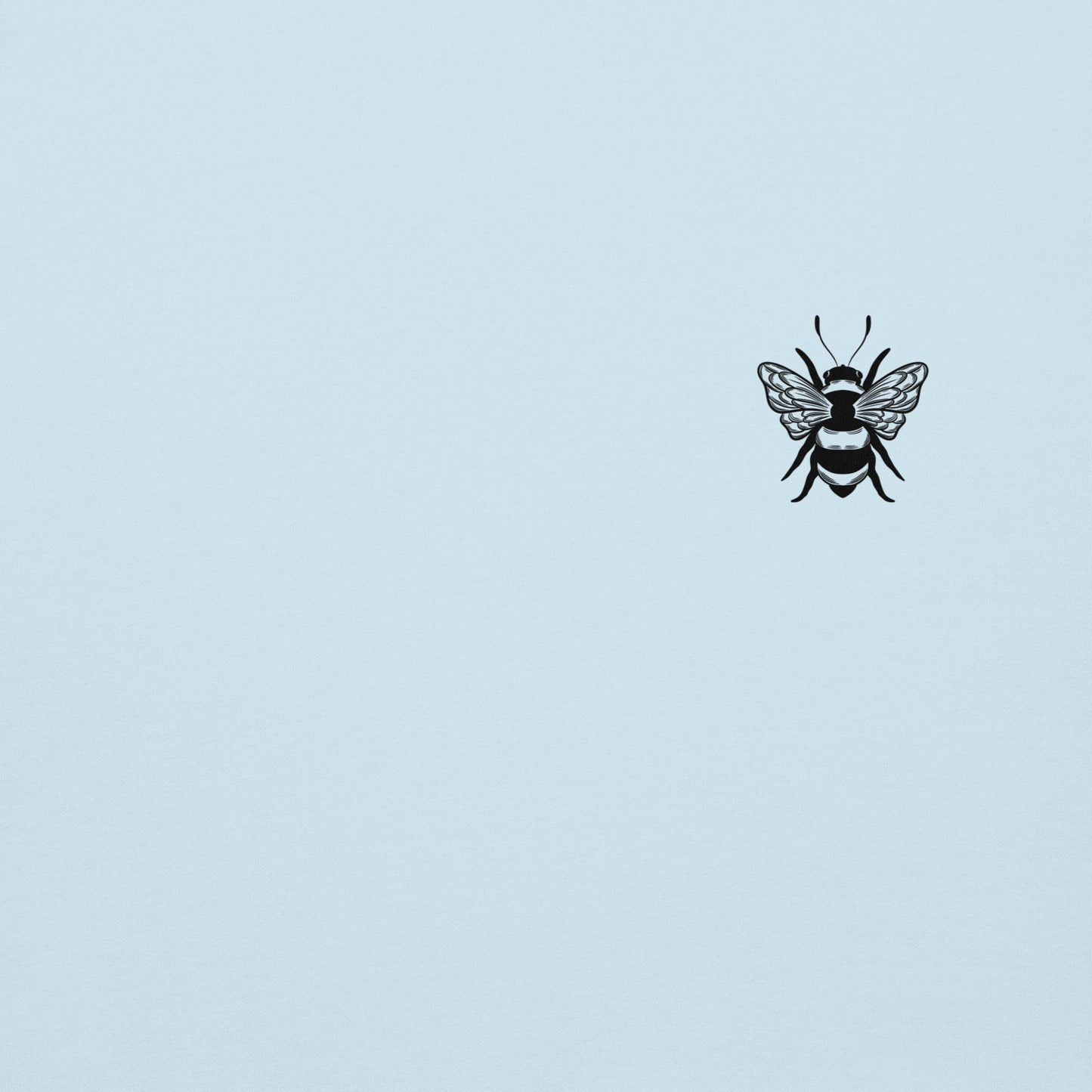 Close-up of a small black bee graphic on a light blue hoodie.