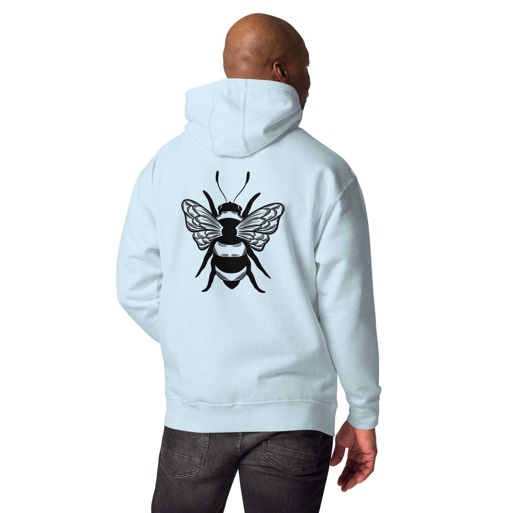 Man in a light blue hoodie with a large black bee graphic on the back, wearing dark jeans.